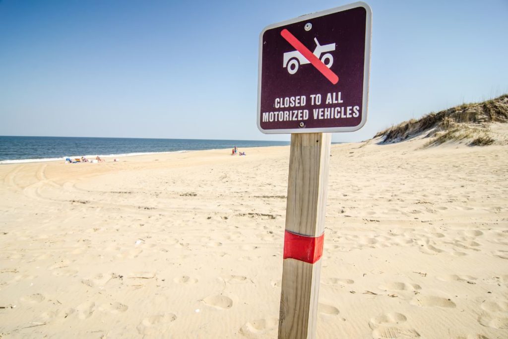 Beach with a sign that says it is closed to motorized vehicles