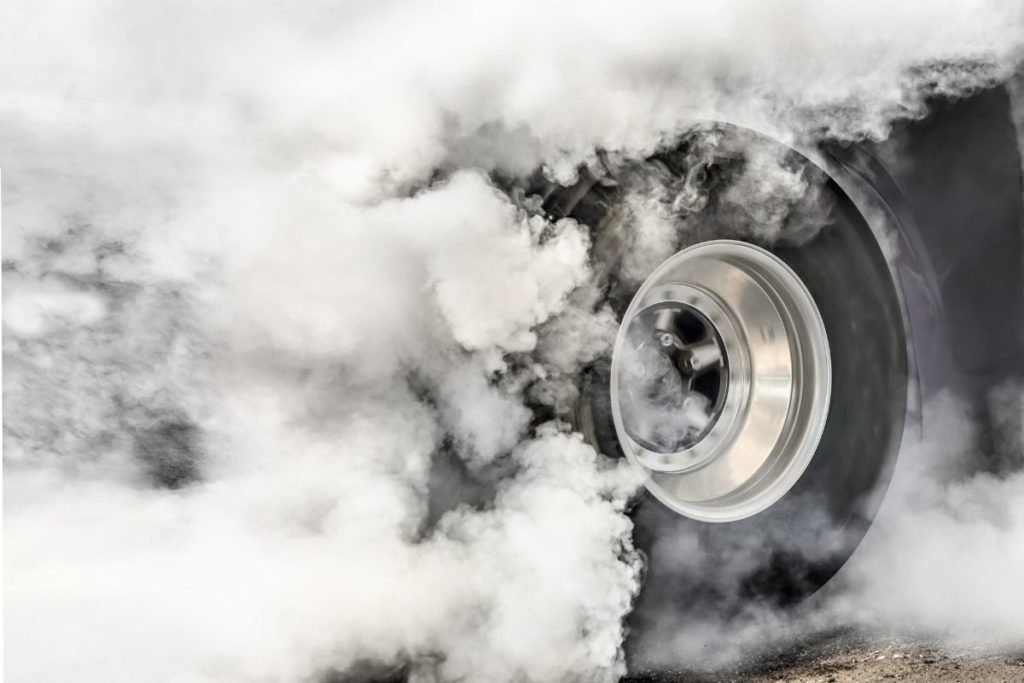 Car tire surrounded by smoke